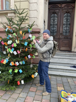 Geschenkebaum mit Pfarrperson